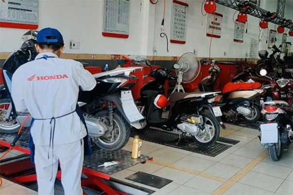 Hình ảnh kỹ thuật viên tiếp nhận và kiểm tra xe cho khách hàng tại cửa hàng Đức Dung. 
